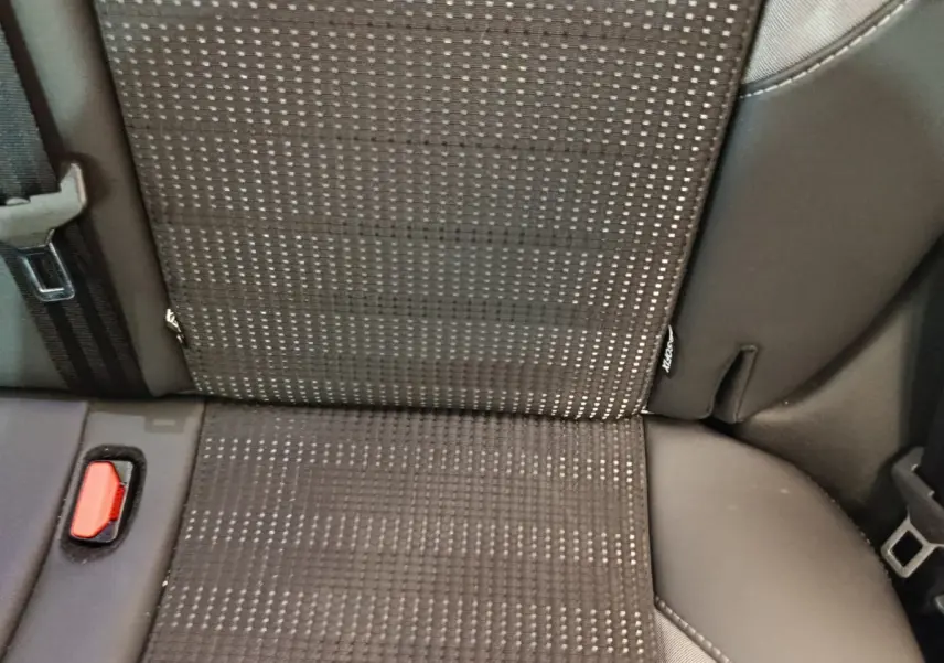 Gros plan sur la banquette arrière gris foncé du Peugeot 2008 avec ceinture et bouton d'attache visible.
