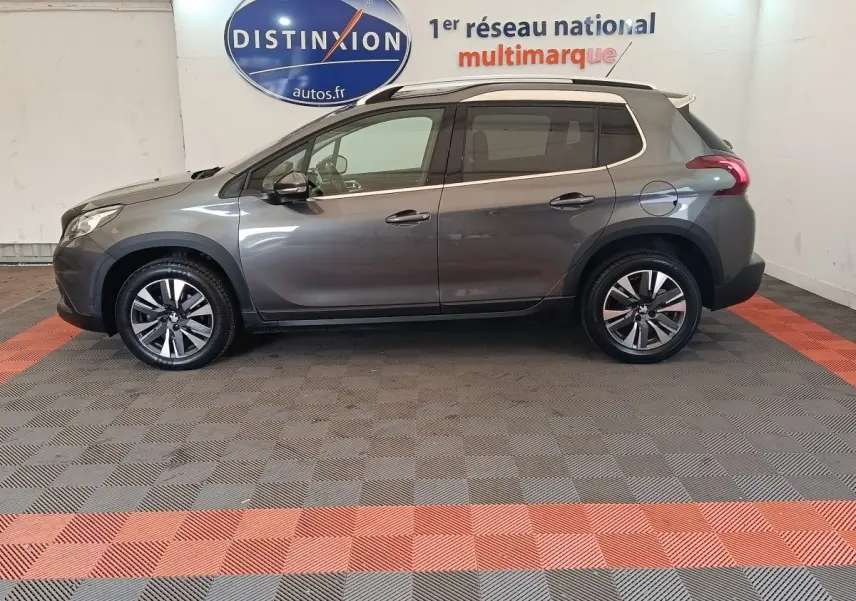 Profil droit d'un Peugeot 2008 gris foncé de 2019, version Puretech Allure, avec jantes alliage et toit blanc contrasté.