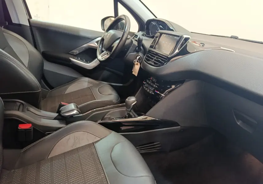 Vue intérieure côté conducteur du Peugeot 2008 gris foncé, avec tableau de bord tactile et volant cuir multifonctions.