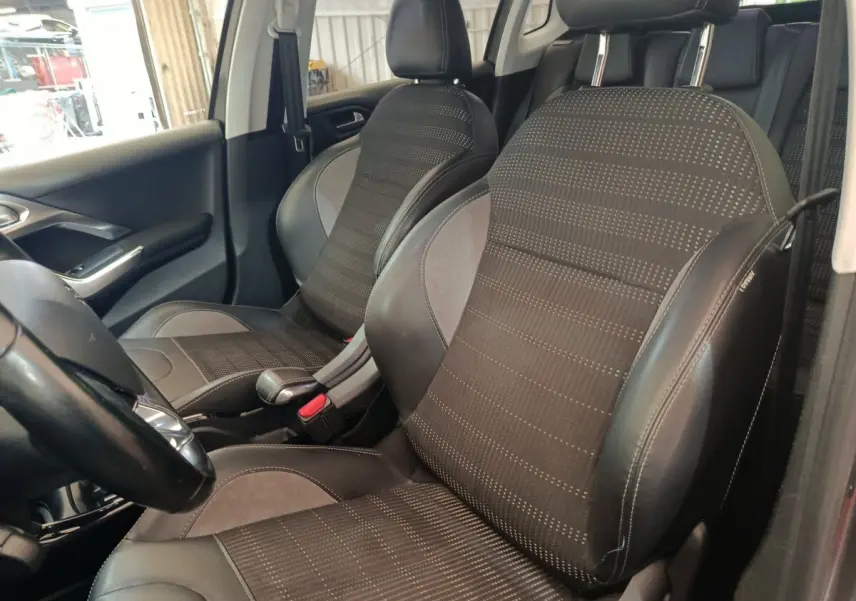 Vue intérieure rapprochée des sièges avant en tissu et cuir noir du Peugeot 2008 gris foncé, version Allure 2019.