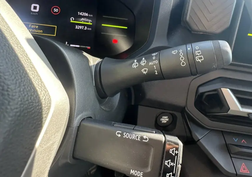 Gros plan sur la commande multifonction et le commodo d’essuie-glace du tableau de bord du Dacia Duster 2025.