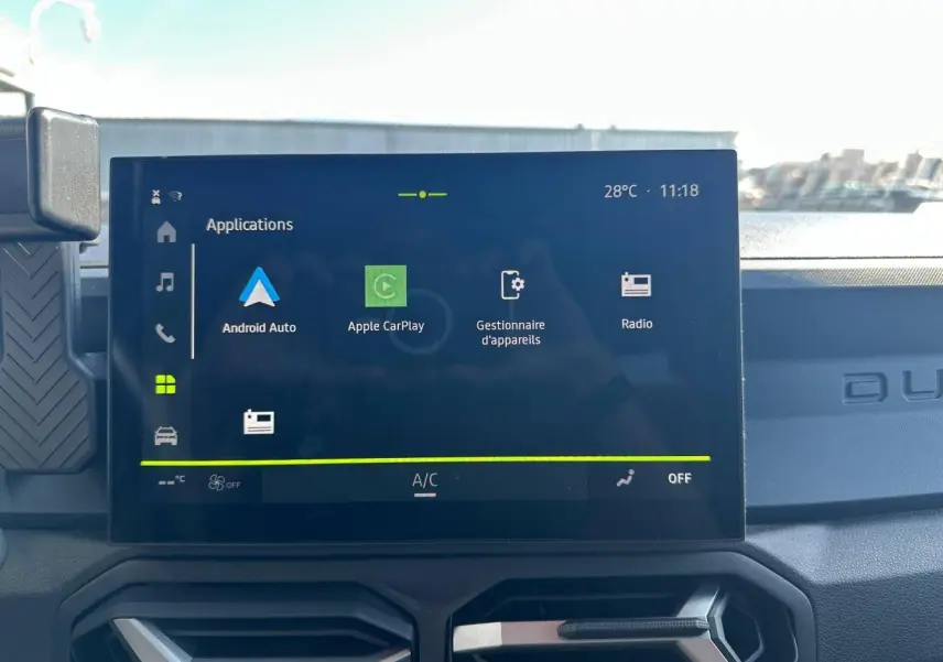 Écran tactile central du tableau de bord du Dacia Duster 2025, affichant les applications Android Auto et Apple CarPlay.