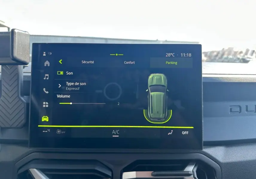 Écran tactile central du Dacia Duster 2025 affichant les réglages sonores et l'interface de parking.
