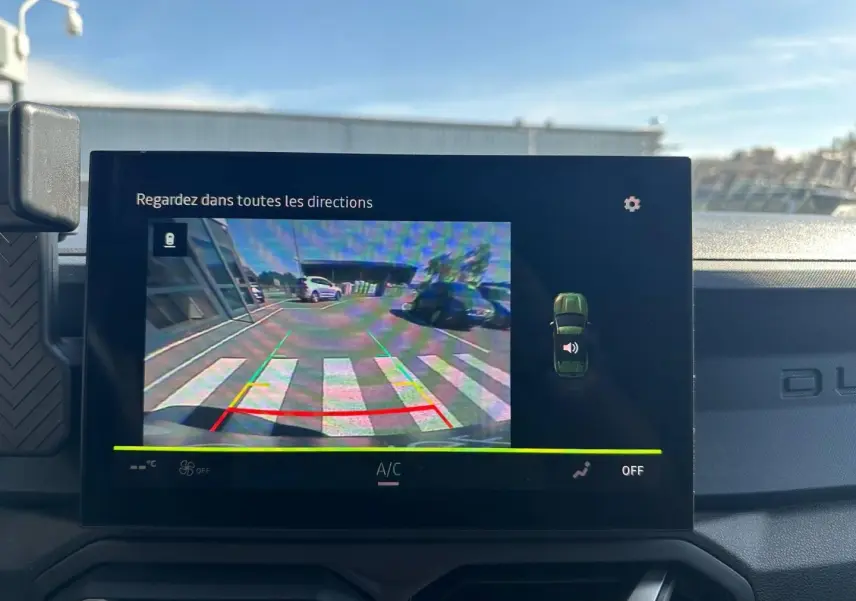 Écran tactile intérieur montrant la caméra de recul du Dacia Duster 2025 couleur Sandstone en stationnement.