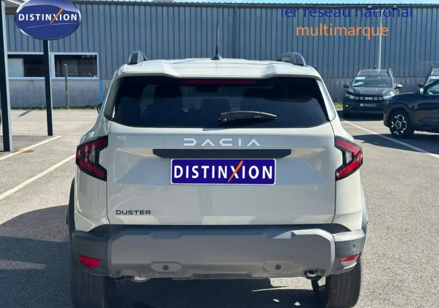 Vue arrière d'un Dacia Duster 2025 couleur Sandstone avec logo DACIA et feux arrière LED distinctifs.