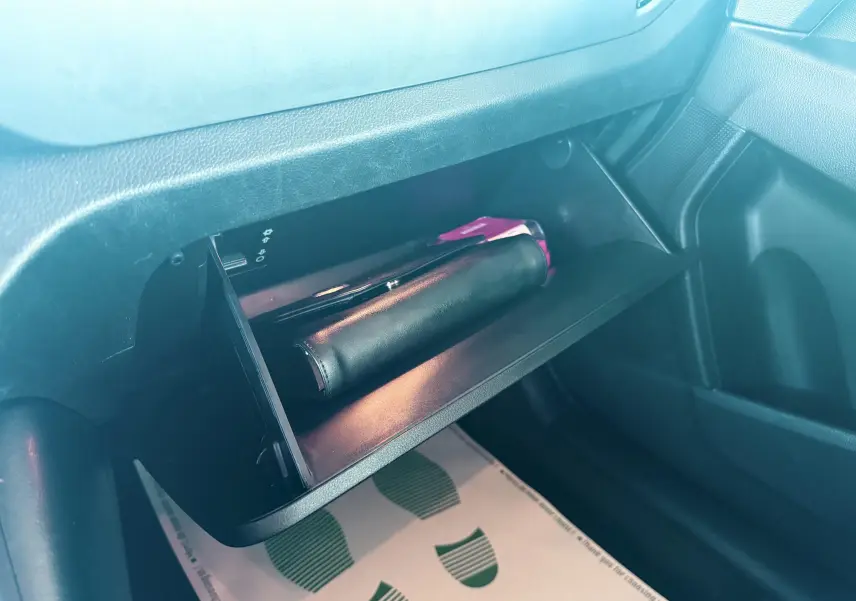 Gros plan sur la boîte à gants ouverte du Kia Sportage 2015 avec un étui noir à l'intérieur.