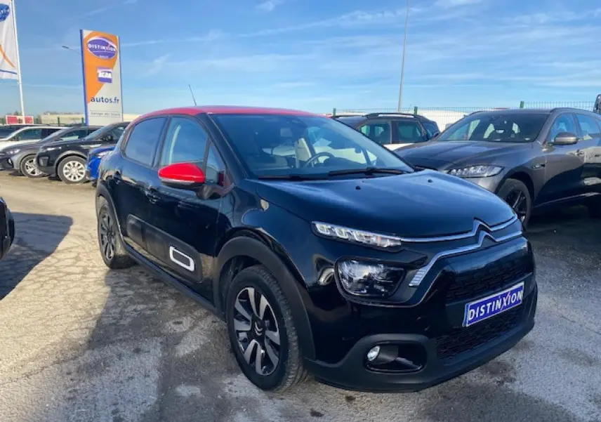 Citroën C3 2023 noir avec toit et rétroviseurs rouges, vue 3/4 avant sur parking ensoleillé.