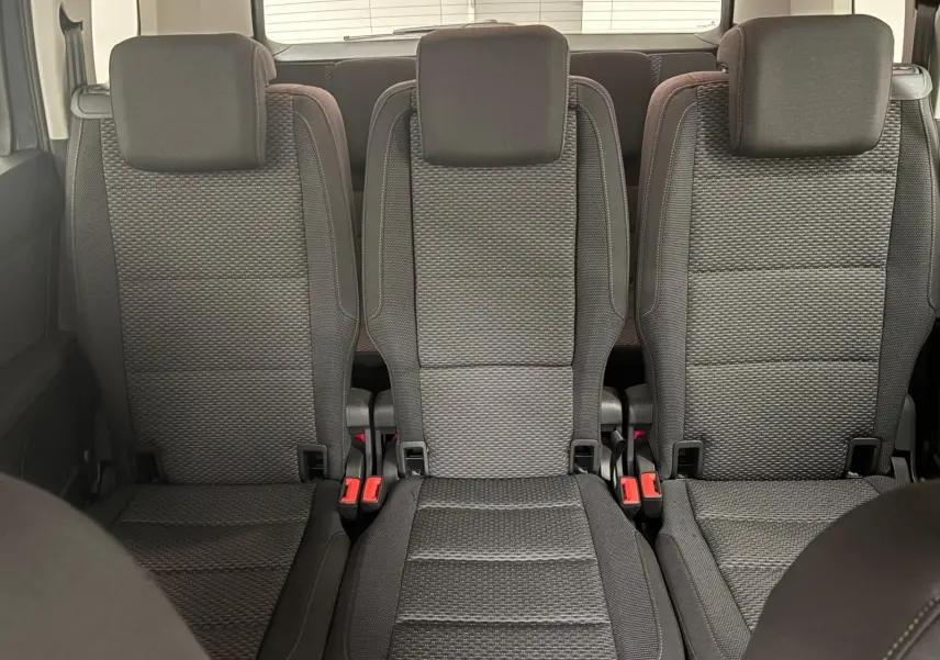 Vue intérieure des trois sièges arrière en tissu gris du Volkswagen Touran 2025, version 7 places.