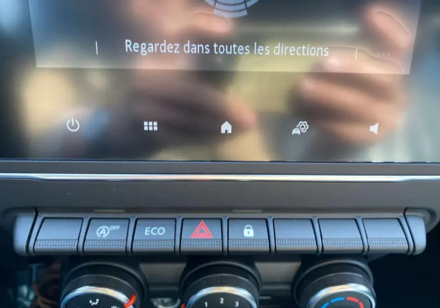 Gros plan sur la console centrale de la Renault Clio noire 2025, montrant les commandes climatisation et boutons multifonctions.