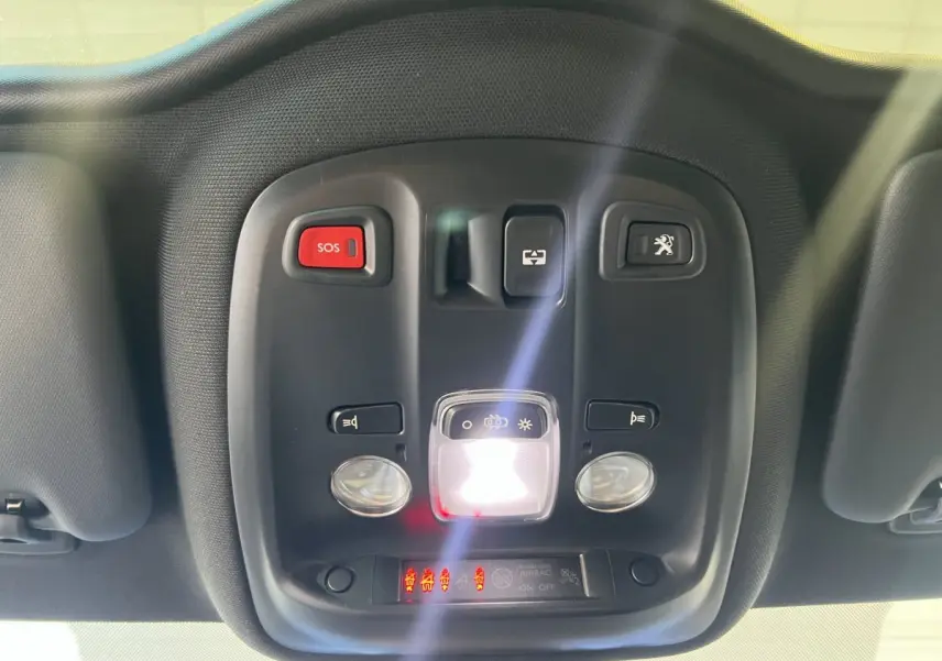 Vue en gros plan du plafonnier intérieur noir avec boutons SOS et ouverture coffre de la Peugeot 308 rouge