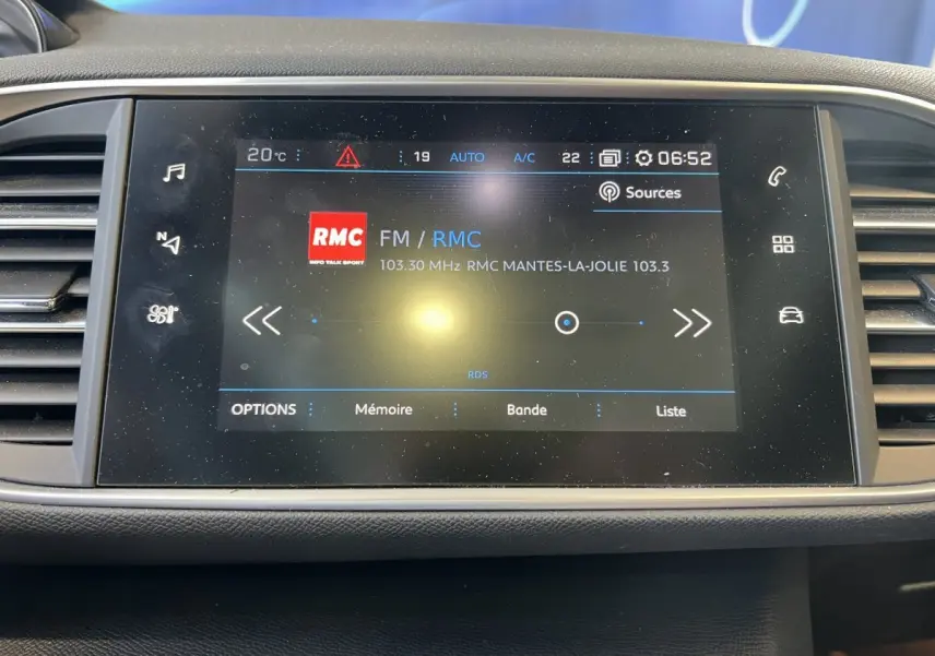 Écran tactile central de la Peugeot 308 GT Line 2019 affichant la radio FM RMC à 6h52.