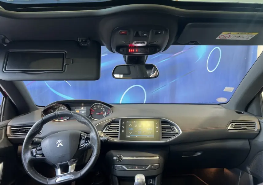 Intérieur avant de la Peugeot 308 GT Line 2019, tableau de bord noir avec écran tactile central et volant cuir multifonctions.