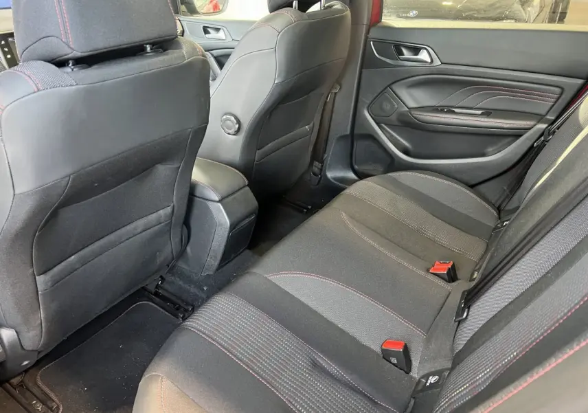 Vue intérieure arrière droite sur la banquette noire avec surpiqûres rouges de la Peugeot 308 GT Line rouge de 2019.