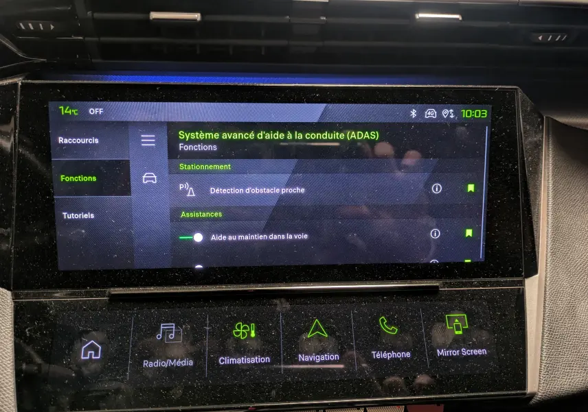 Écran tactile central du tableau de bord de la Peugeot 308 SW Hybrid gris, affichant les aides à la conduite avancées.