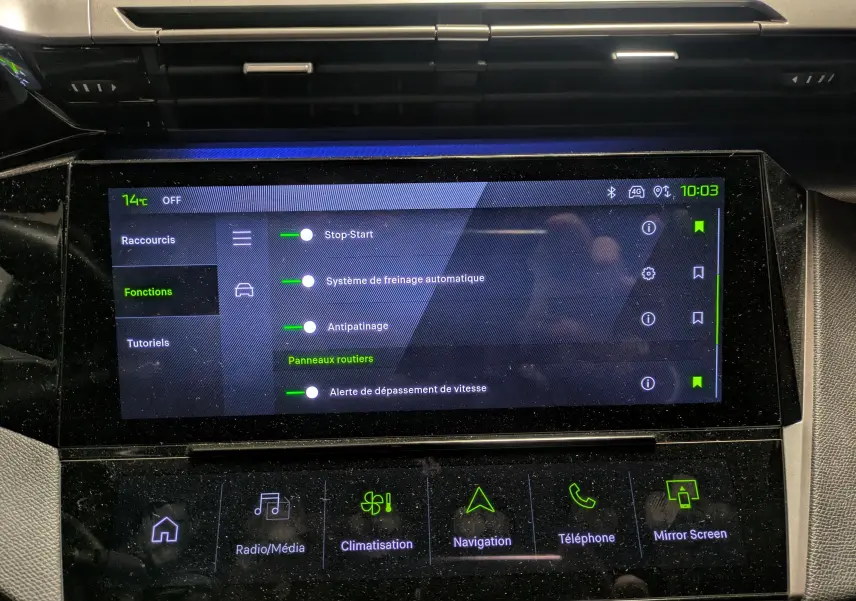 Vue rapprochée de l’écran tactile central du Peugeot 308 SW Hybrid 145 eDCS6 GT gris, affichant les fonctions d’aide à la conduite.