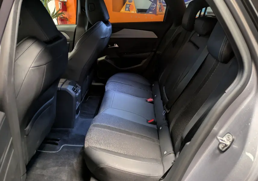 Vue intérieure côté droit des sièges arrière en sellerie mixte tissu et cuir gris du Peugeot 308 SW Hybrid 145 eDCS6 GT 2025.