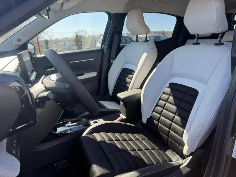 Intérieur avant du Citroën C3 Aircross 2026, sièges bicolores blanc et noir, volant et console centrale visibles côté conducteur.