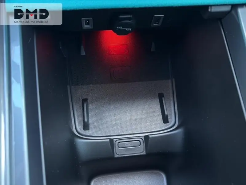 Gros plan sur le compartiment de rangement central avec éclairage rouge intérieur de la Fiat 600 rouge hybride 2026.