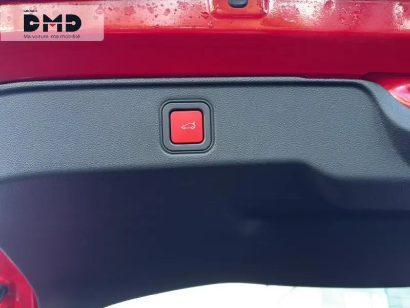 Bouton rouge d'ouverture électrique du coffre sur la partie intérieure du hayon d'une FIAT 600 rouge 2026.