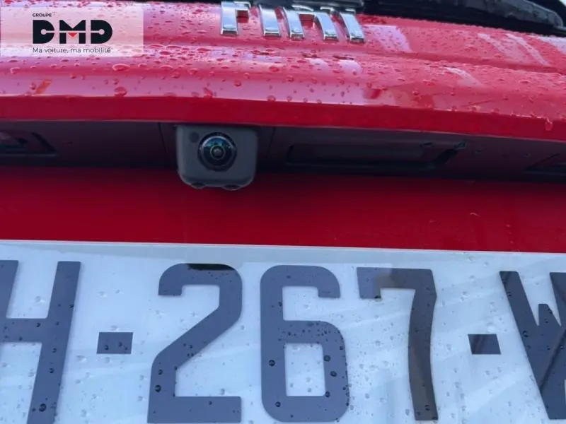 Gros plan sur la caméra de recul et la plaque d’immatriculation d’une FIAT 600 rouge, vue arrière.