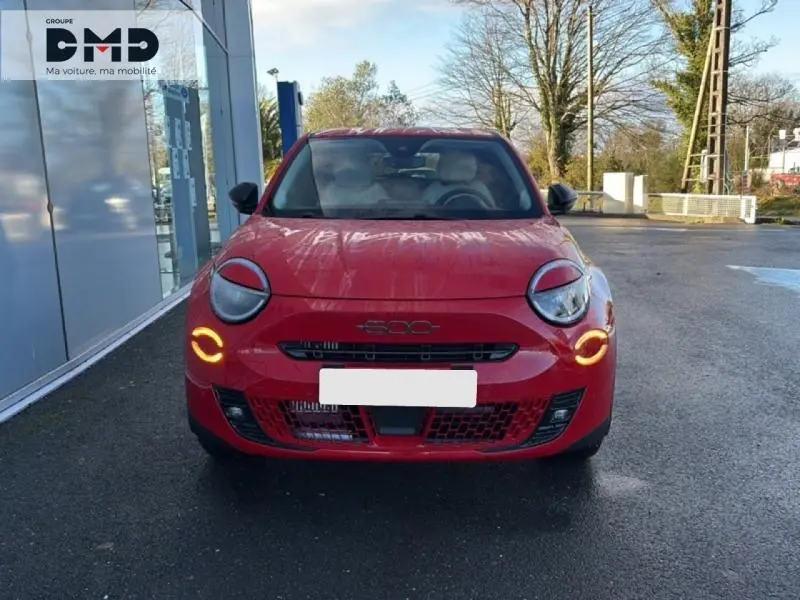 Vue frontale d'une FIAT 600 rouge avec feux de jour LED circulaires allumés sur un parking extérieur.