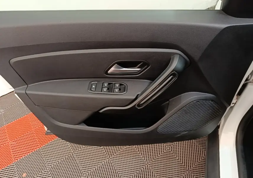 Vue intérieure de la porte avant gauche du Dacia Duster blanc, avec commandes électriques des vitres et poignée noire.