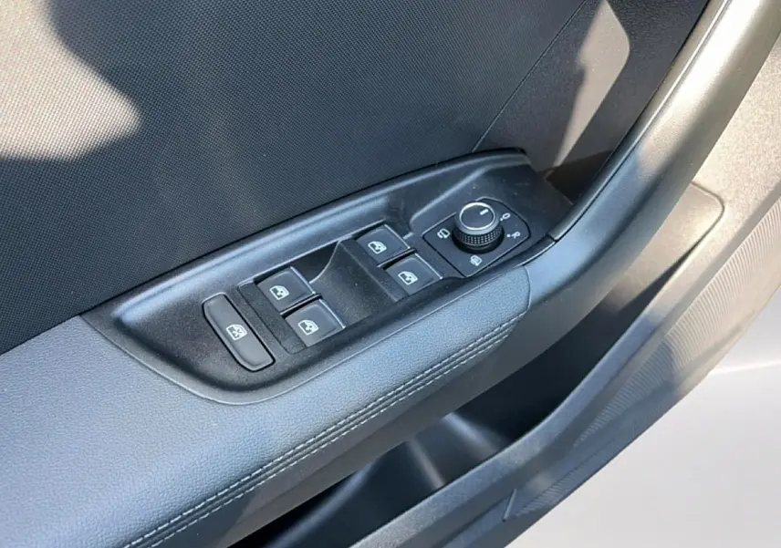 Gros plan sur les commandes de lève-vitres et rétroviseurs côté conducteur de l'Audi A1 Sportback blanc et noir.