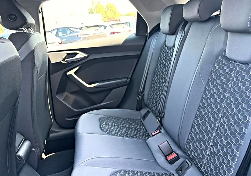 Vue intérieure côté droit des sièges arrière gris foncé avec motifs géométriques d'une Audi A1 Sportback 2026.