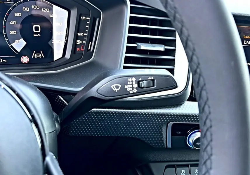 Vue rapprochée du tableau de bord et volant cuir noir de l’Audi A1 Sportback 30 TFSI, affichage digital et commandes intégrées.