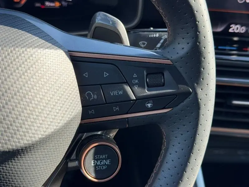 Gros plan sur le volant perforé du CUPRA Formentor 2025 avec boutons multifonctions et bouton start/stop éclairé.