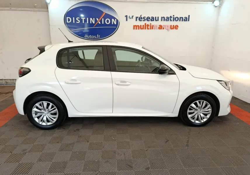 Profil droit d'une Peugeot 208 blanche 2023, version 1.5 BlueHDi Premium, en intérieur sur sol damier gris et orange.