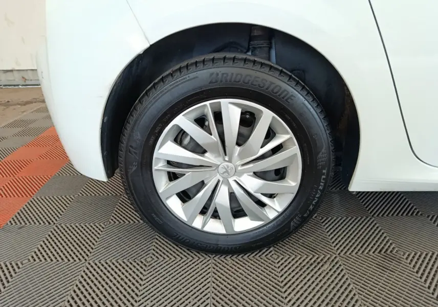 Gros plan sur la roue arrière droite blanche d'une Peugeot 208 1.5 BlueHDi avec jante argentée et pneu Bridgestone.