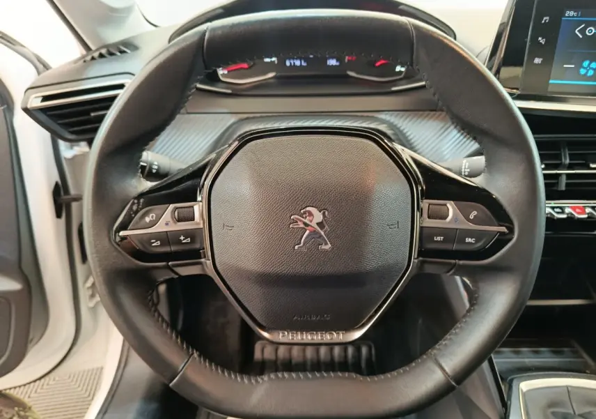 Vue rapprochée du volant cuir multifonctions noir de la Peugeot 208 1.5 BlueHDi 100 S&S Premium blanche de 2023.