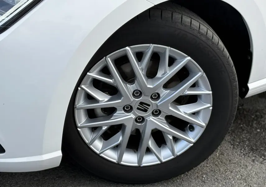 Gros plan sur la jante alliage 16 pouces argentée et le pneu Bridgestone du côté avant gauche d'une SEAT Ibiza blanche.
