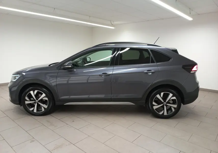 Profil droit du Volkswagen Taigo gris cendré 2025 avec jantes alliage Aberdeen et feux arrière LED allumés.