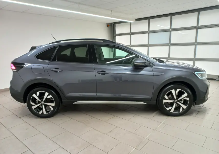 Vue de profil côté gauche du Volkswagen Taigo gris cendré 2025 avec jantes alliage et lignes épurées.