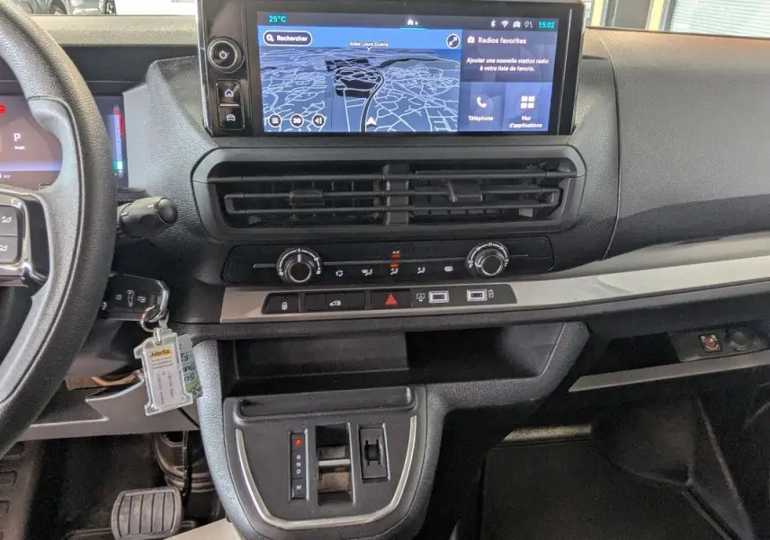 Vue intérieure du tableau de bord du Fiat Scudo Fourgon blanc 2025, avec écran tactile GPS et commandes climatisation visibles.