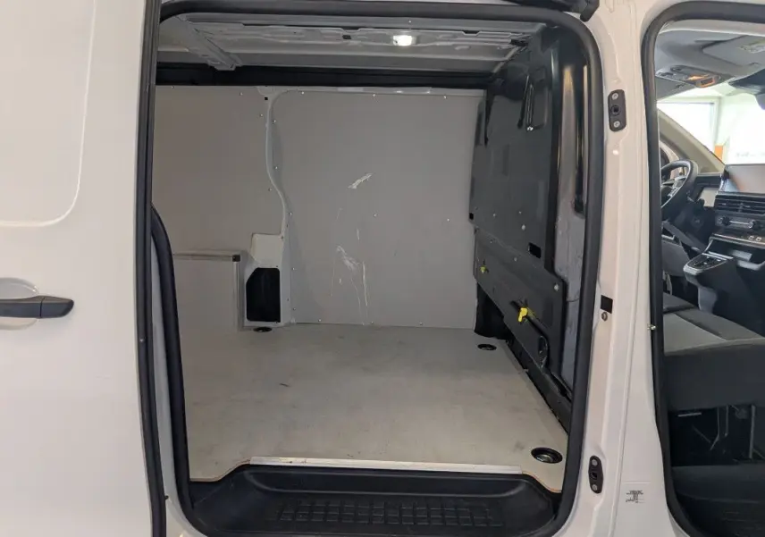 Vue intérieure du coffre blanc du FIAT Scudo Fourgon XL 145 EAT8 2025 avec porte latérale ouverte à 180 degrés.
