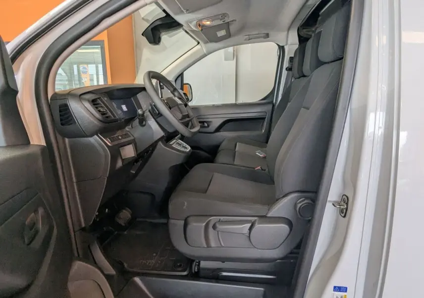 Vue intérieure côté conducteur du Fiat Scudo Fourgon blanc 2025, montrant les sièges modulables et le tableau de bord.