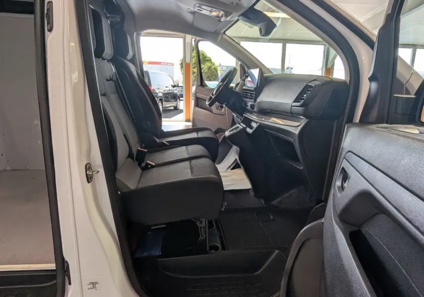 Intérieur côté conducteur du FIAT Scudo Fourgon blanc 2025, montrant les sièges avant et le tableau de bord moderne.