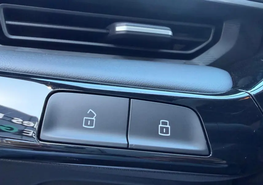 Gros plan sur les boutons de verrouillage centralisé dans l'habitacle noir brillant du MG3 Pebble Black 2026.
