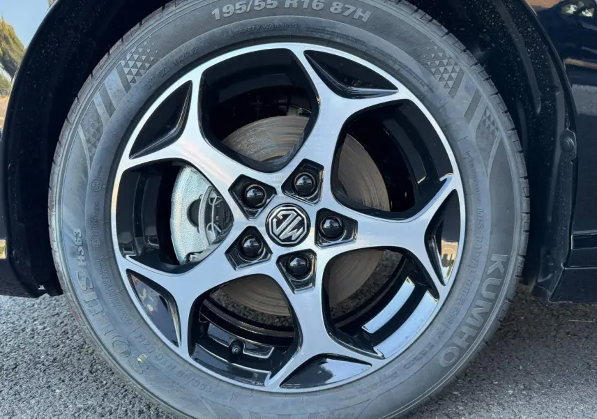 Gros plan sur la jante alu noire et argentée avec logo MG d'une MG3 Pebble Black métallisé, côté gauche.