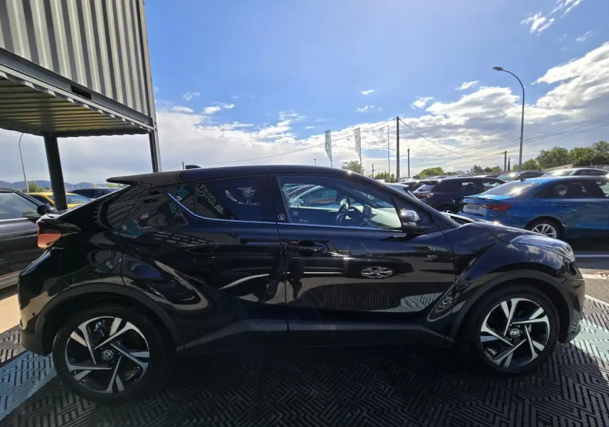 Profil côté gauche du Toyota C-HR noir métal 2023 avec jantes alliage et lignes sculptées distinctives.