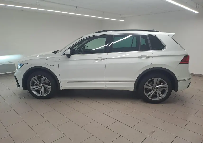 Volkswagen Tiguan 1.4 eHybrid R-Line blanc pur vu de profil côté gauche en intérieur showroom.
