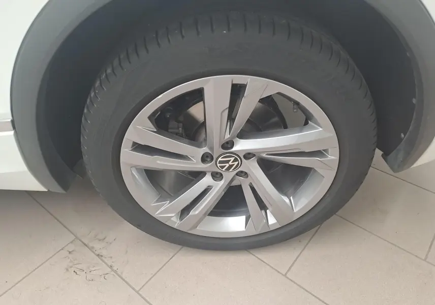 Gros plan sur la jante alliage argentée du Volkswagen Tiguan blanc pur 1.4 eHybrid 245 DSG6 R-LINE 2023.