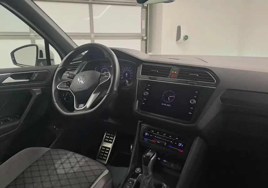 Intérieur du Volkswagen Tiguan 1.4 eHybrid R-Line 2023, vue côté conducteur, tableau de bord moderne et volant multifonction noir.