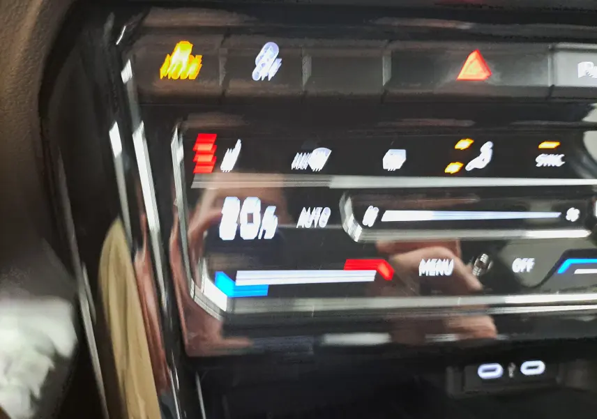 Gros plan sur la console centrale tactile du Volkswagen T-Roc 1.5 TSI R-Line, affichant les réglages de climatisation.