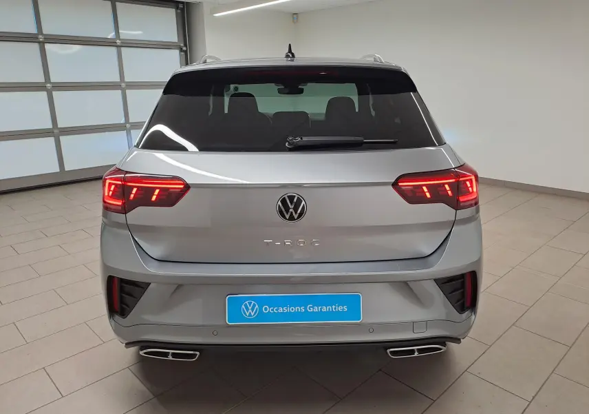 Vue arrière du Volkswagen T-Roc gris pyrite 2025 avec feux LED allumés et double sortie d’échappement chromée.