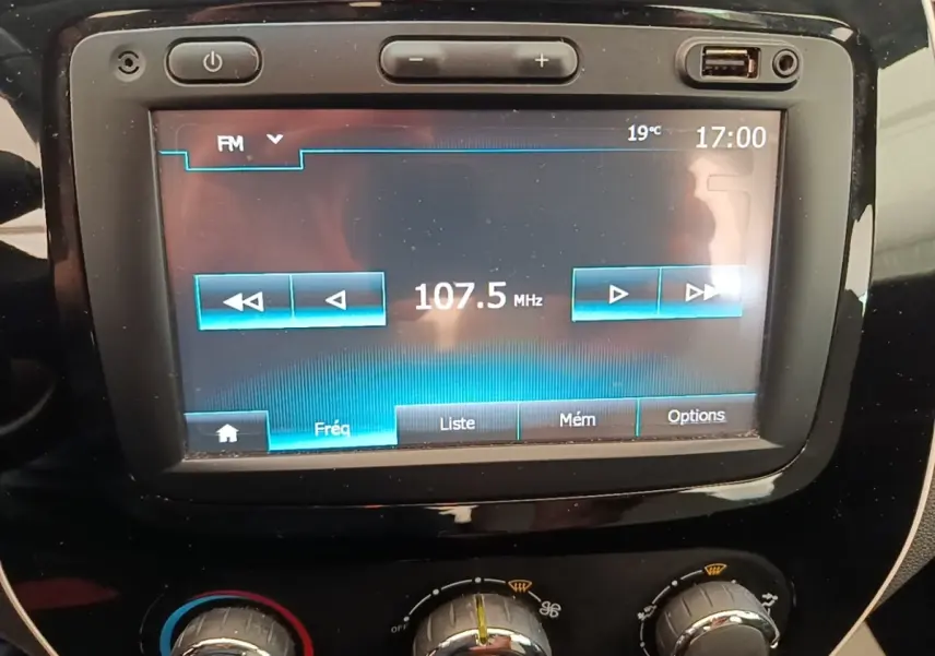 Gros plan sur l’écran tactile central et les commandes de climatisation du Renault Captur Zen TCe 90 gris clair.