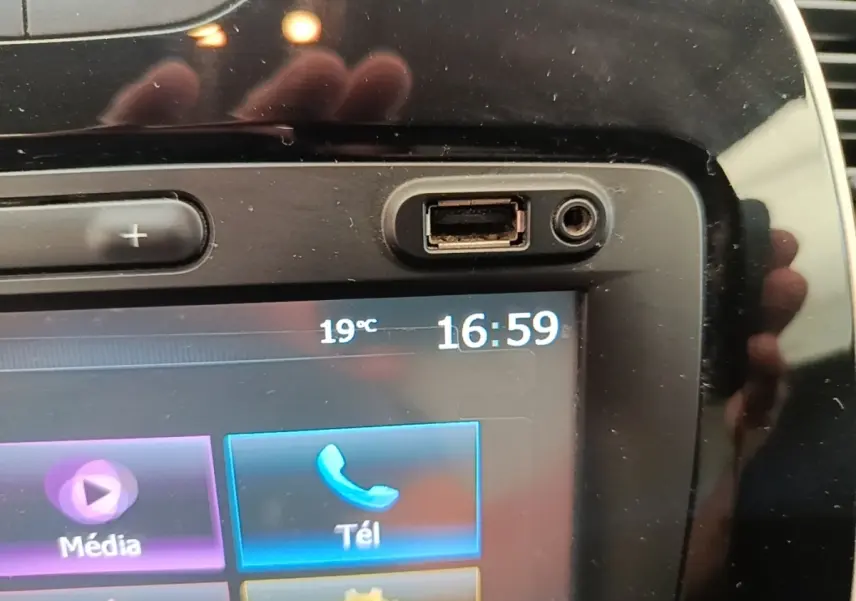 Gros plan sur l’écran tactile multimédia noir du Renault Captur gris clair, affichant l’heure et la température extérieure.